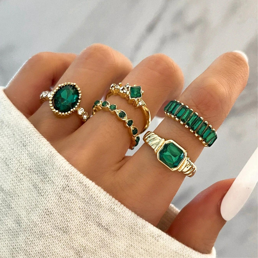 Set of three gold stacking rings with small green zirconia accents. By Sophi.