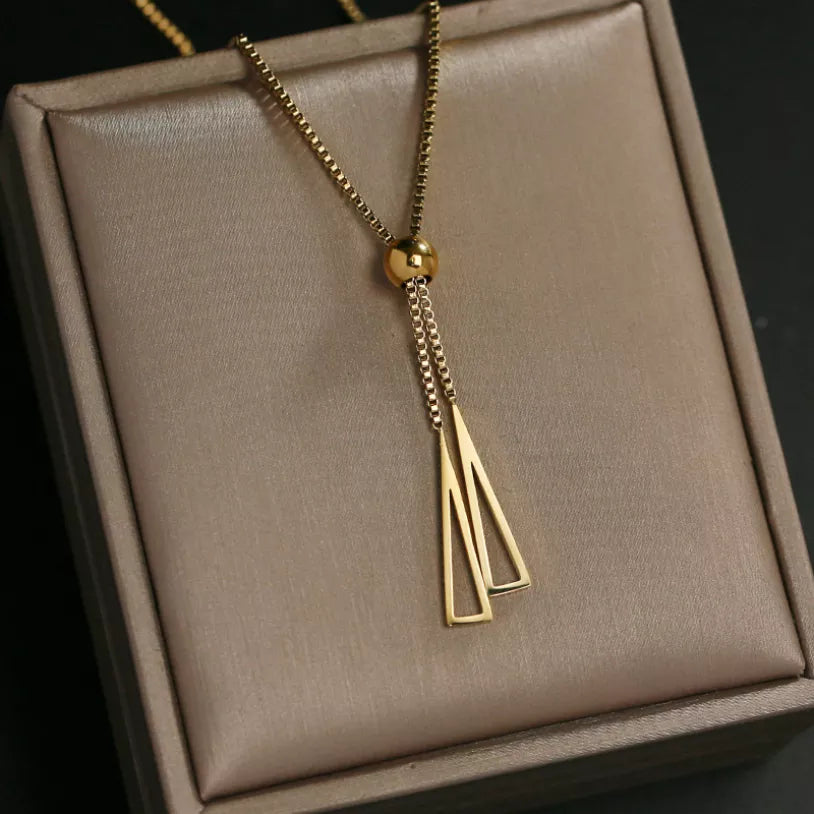 Long gold-toned chain ending in a slim tassel pendant. By Sophi.