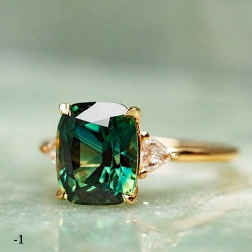 Gold ring with a green gemstone on a light green background