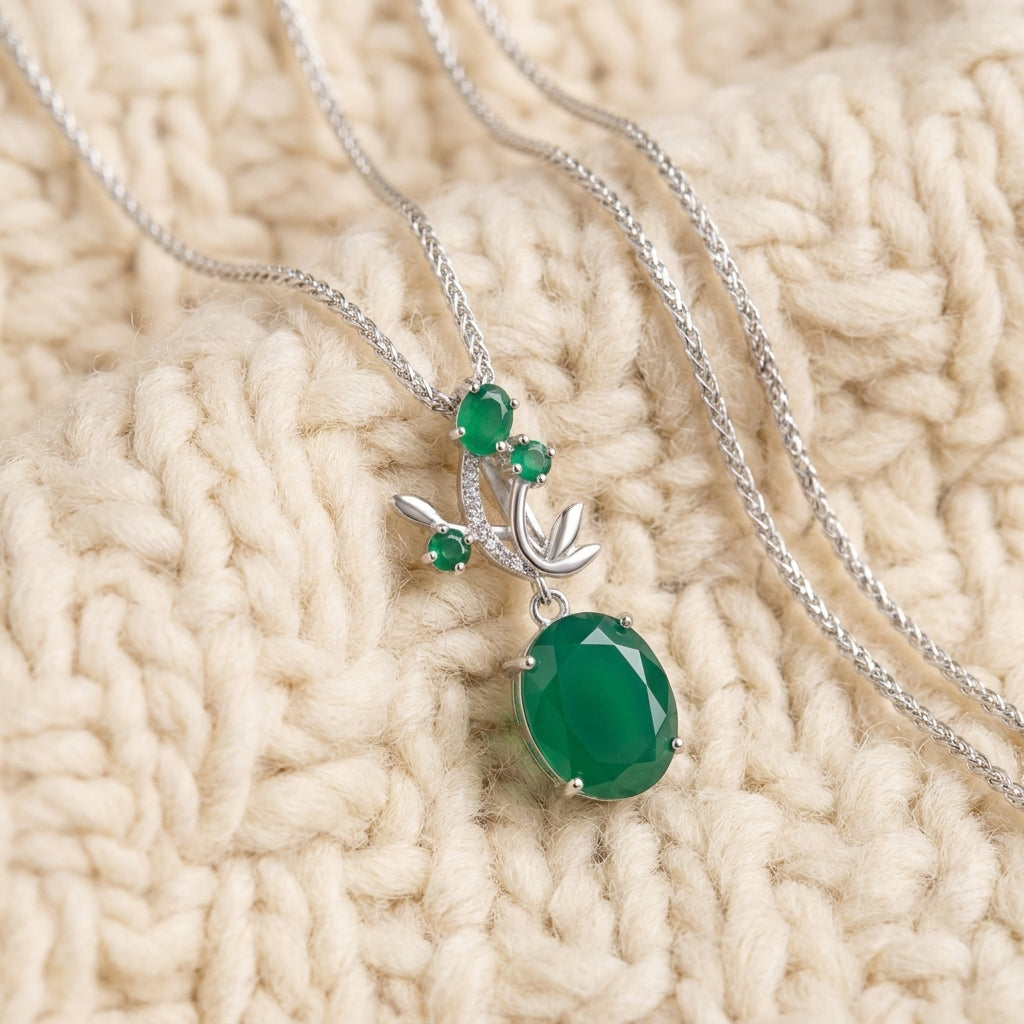 Green agate leaf-and-vine sterling silver pendant necklace on warm cream wool