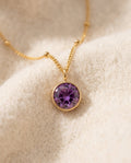 By Sophi Amethyst Birthstone Pendant Necklace flat-lay on warm cream wool