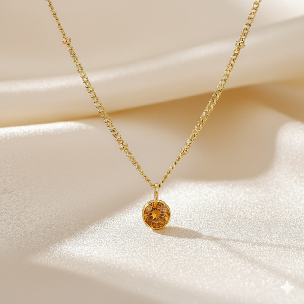 Personalized amber birthstone pendant necklace in gold-toned chain. By Sophi.