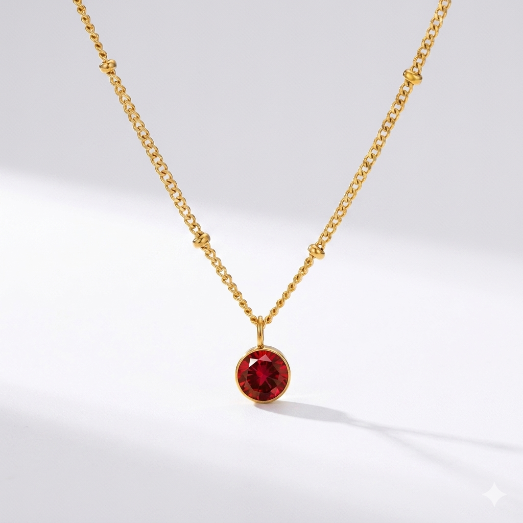 Personalized ruby birthstone pendant necklace in gold-toned chain. By Sophi.