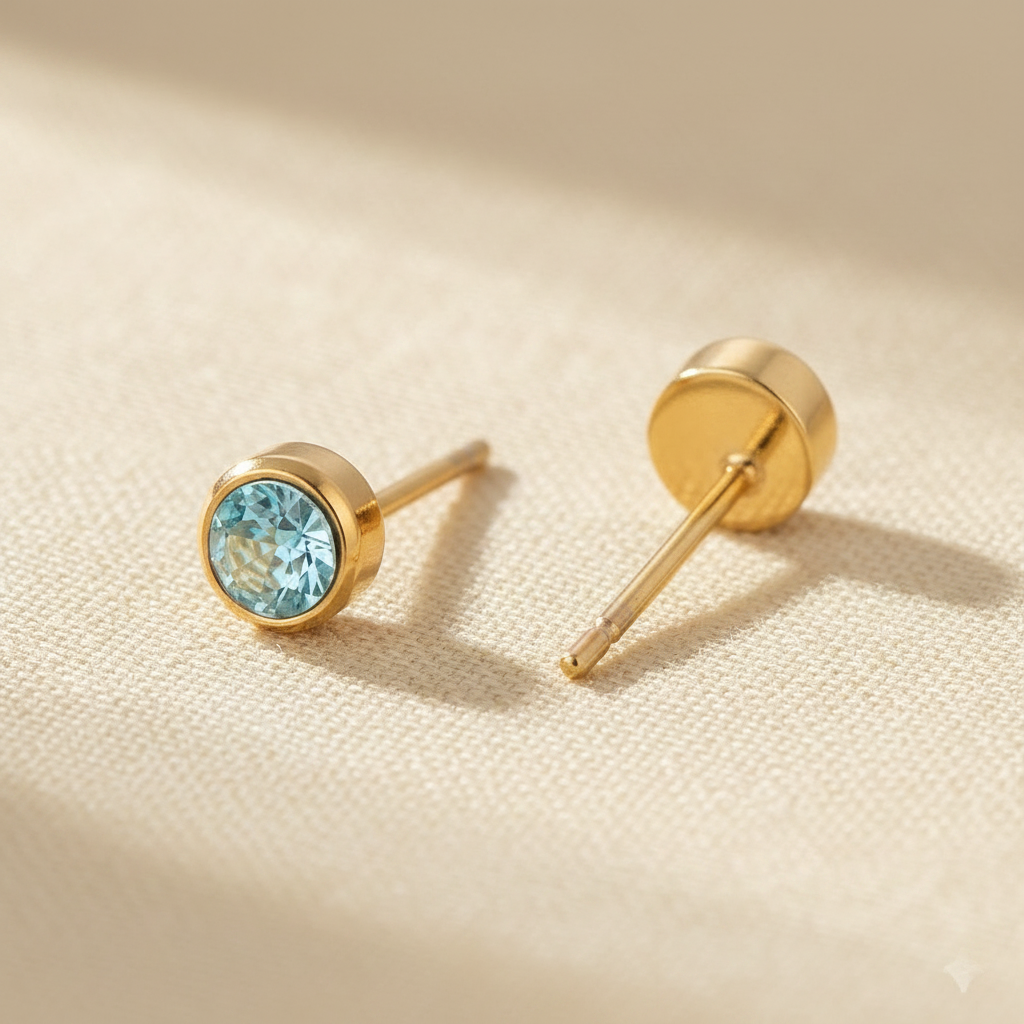 Aquamarine birthstone stud earrings in gold-toned bezel. By Sophi.