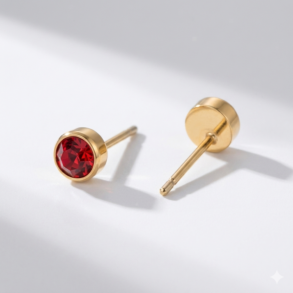 Ruby birthstone stud earrings in gold-toned bezel. By Sophi.
