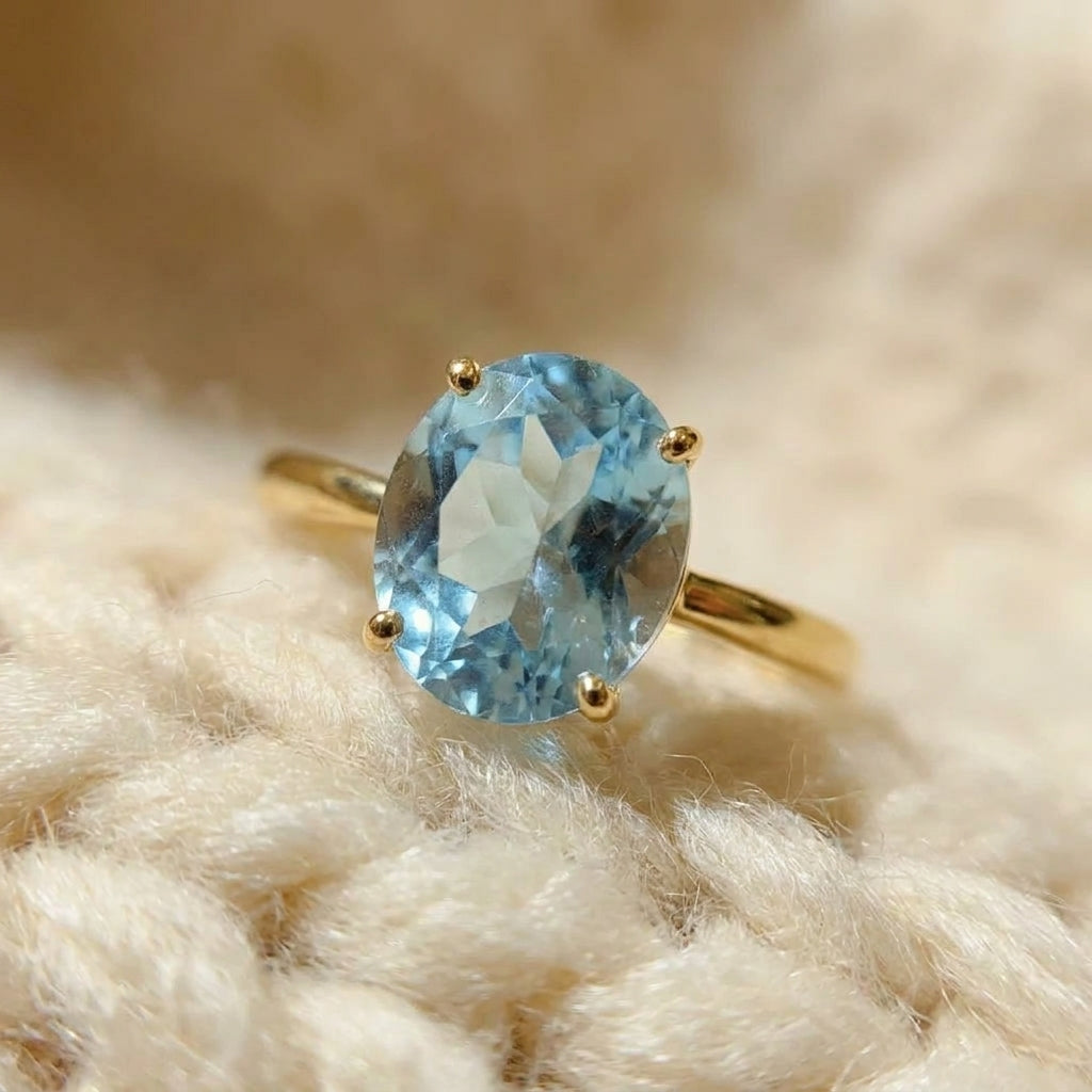 By Sophi Natural Blue Topaz Solitaire Ring in Gold, macro detail of natural blue topaz stone and gold band