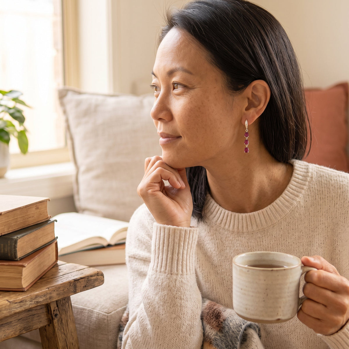 By Sophi Natural Rhodolite Garnet Drop Earrings, lifestyle portrait in cottage reading nook