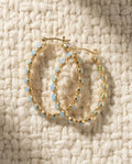 By Sophi Vintage Blue Opal Golden Hoop Earrings flat-lay on warm cream