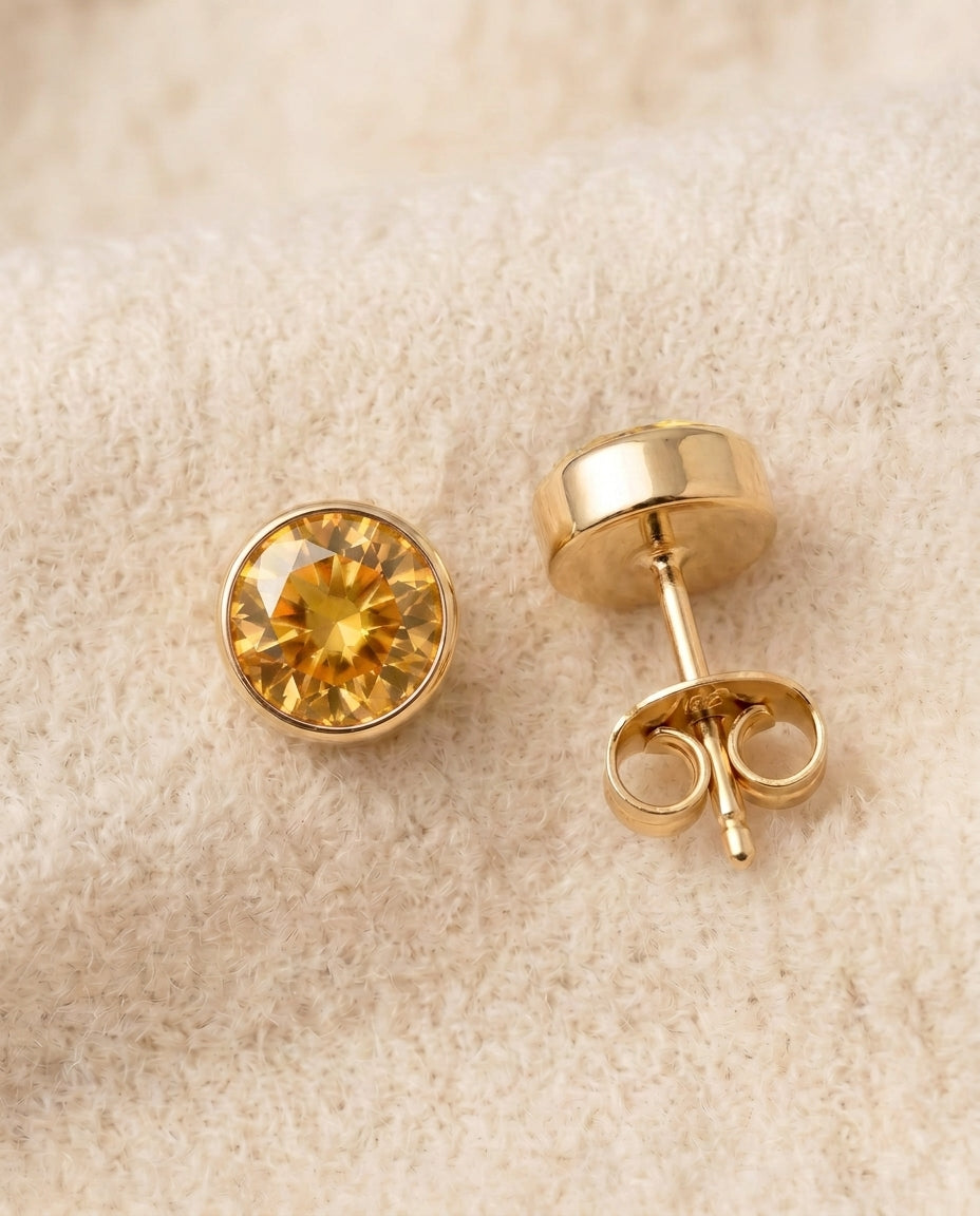 By Sophi Citrine Birthstone Studs flat-lay on warm cream wool
