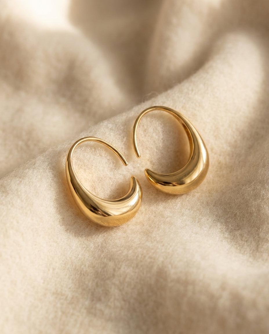By Sophi Luxury Gold and Silver Earrings flat-lay on warm cream wool