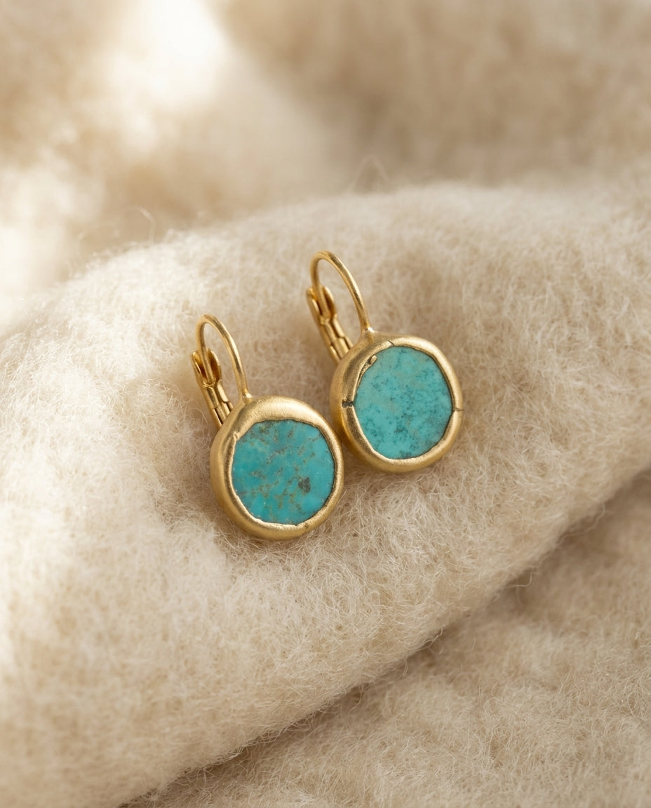 By Sophi Vintage Turquoise Earrings in Gold flat-lay on warm cream wool