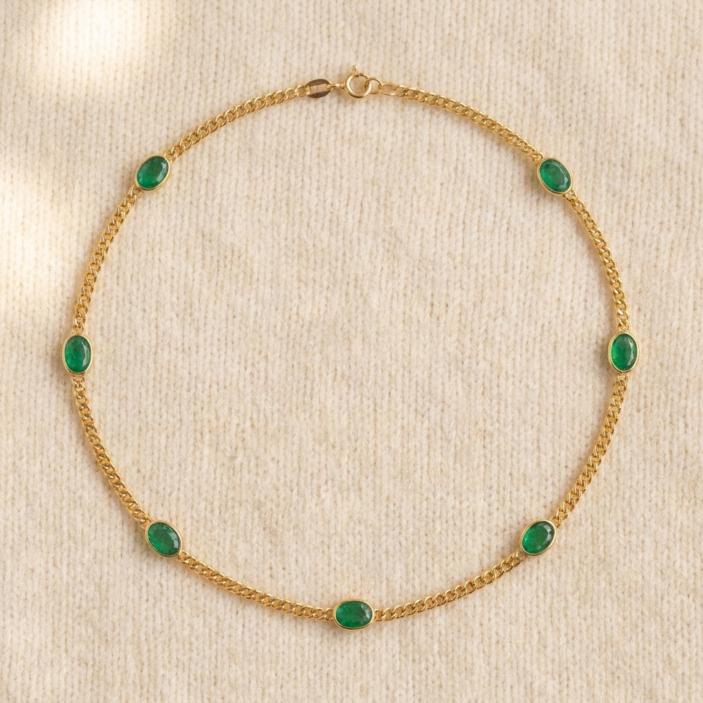 Oval emerald bezel curb chain necklace in gold on warm cream wool, complete necklace