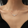 Delicate gold necklace with a single small flower pendant. By Sophi.