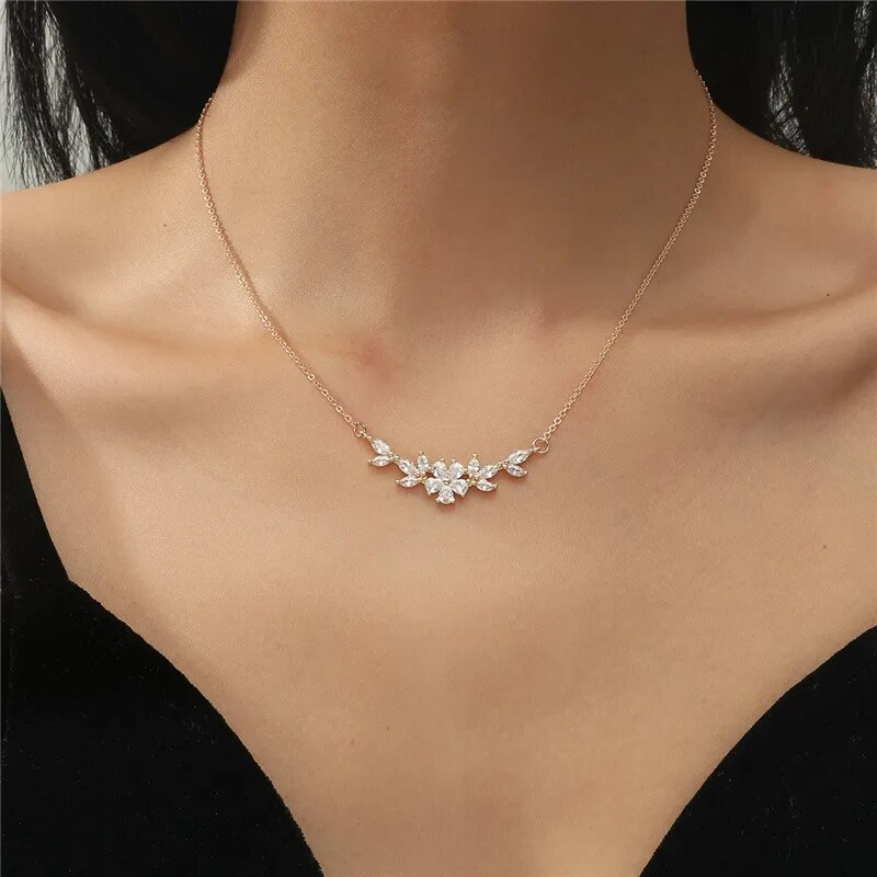 Delicate gold necklace with a single small flower pendant. By Sophi.