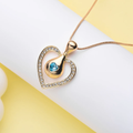 Heart-shaped gold pendant set with a deep blue crystal. By Sophi.