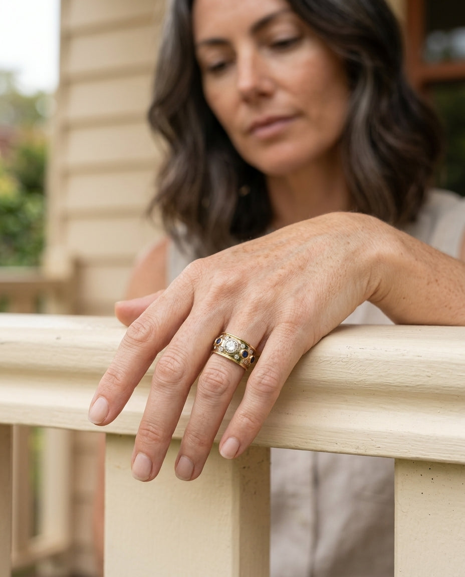 Vintage golden inlaid zirconia ring on hand resting on a porch railing
