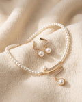 By Sophi Natural Pearl Necklace and Earrings Set flat-lay on warm cream wool
