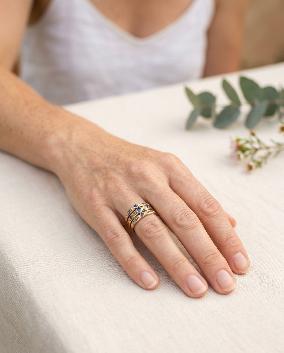 Vintage elegant blue zirconia ring set on hand resting on a linen-covered garden table