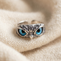 By Sophi Owl of Good Luck Adjustable Ring in Silver and Opal flat-lay on warm cream wool