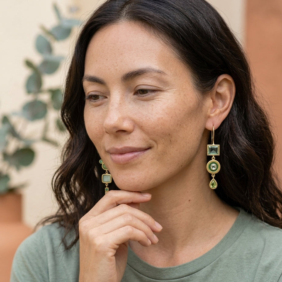 Vintage green dangling earrings on an East Asian woman in a soft garden setting