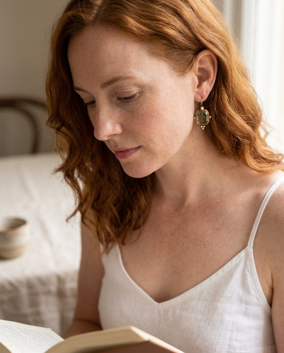 Vintage green and pearl earrings on a red-haired Anglo woman in a quiet cafe