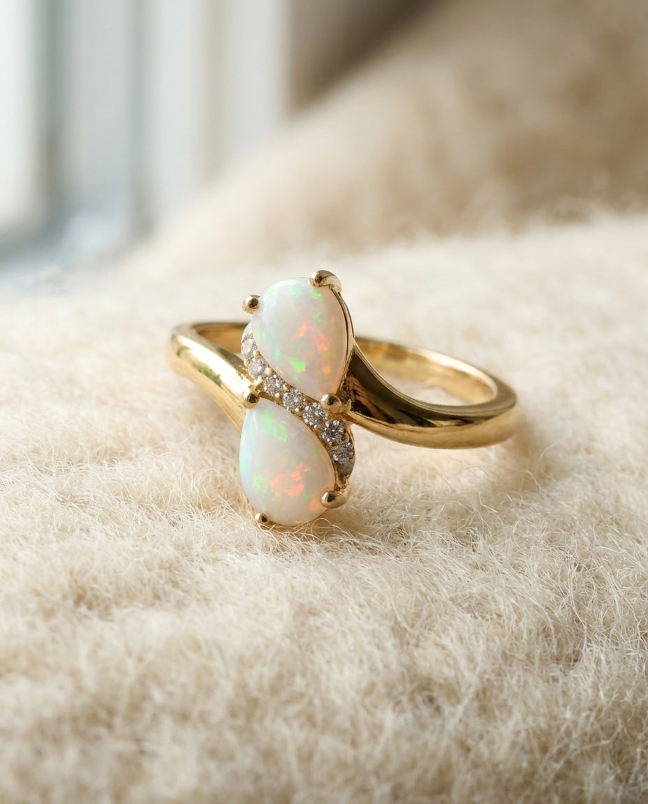 By Sophi Natural Pear-Cut Opal Ring, catalog flat-lay on warm cream wool