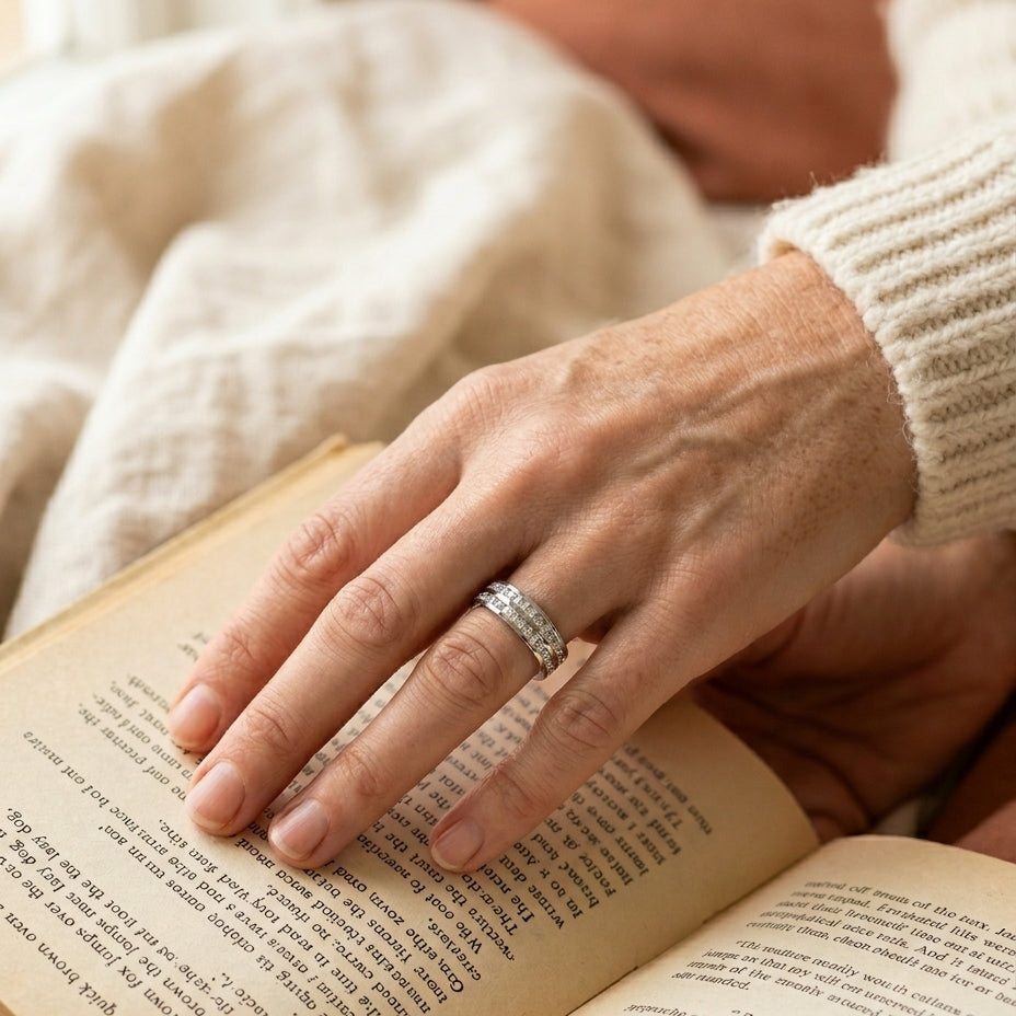 Elegant inlaid zirconia ring on hand holding a book in a quiet reading nook