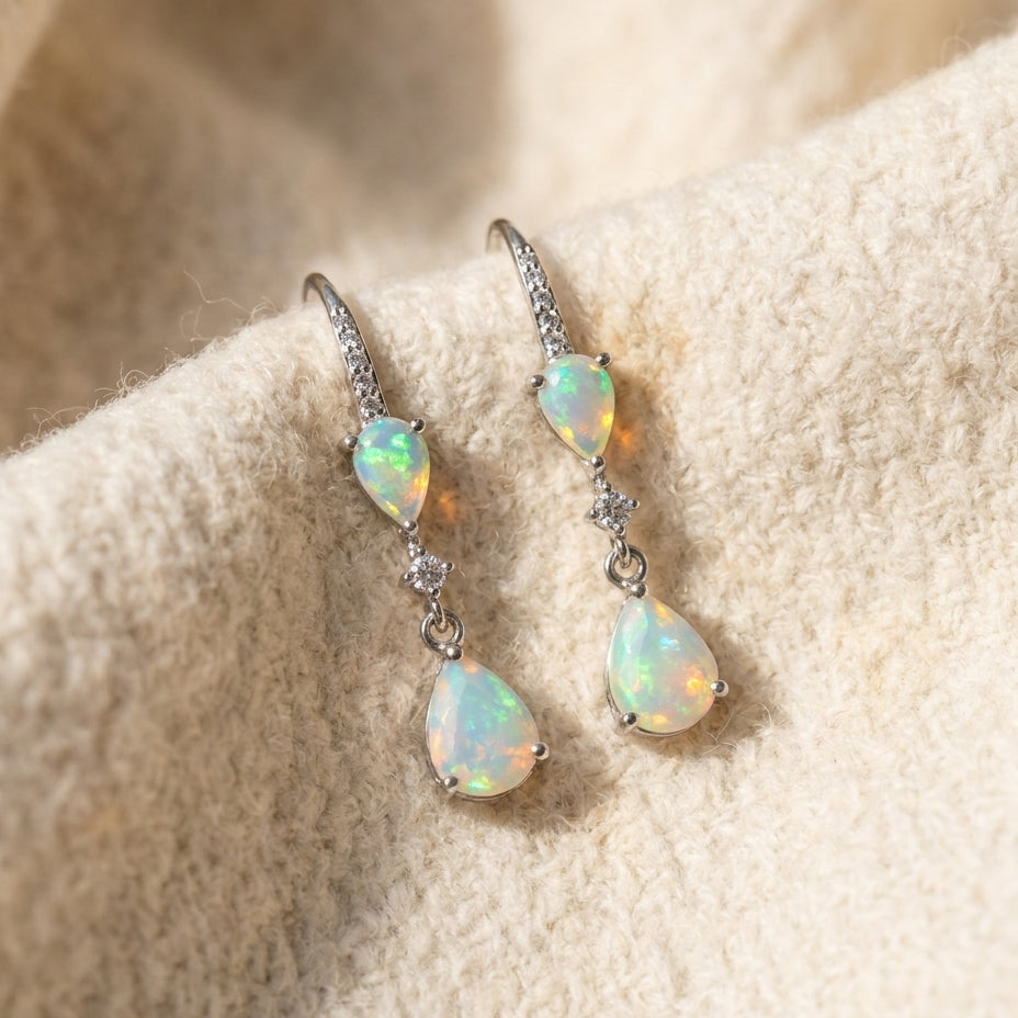By Sophi Natural Opal Drop Earrings, catalog flat-lay on warm cream wool