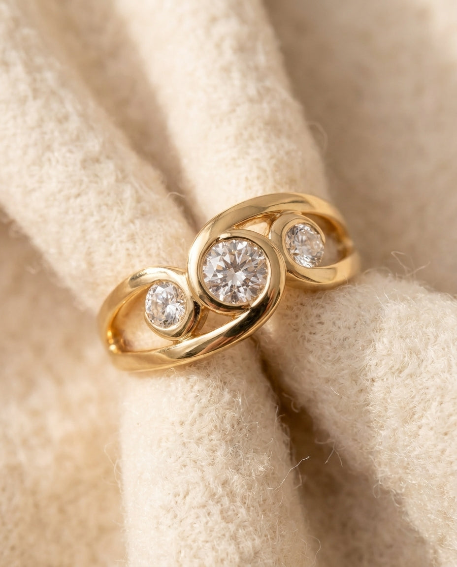 By Sophi Vintage Inlaid Zirconia Spiral Gold Ring flat-lay on warm cream wool