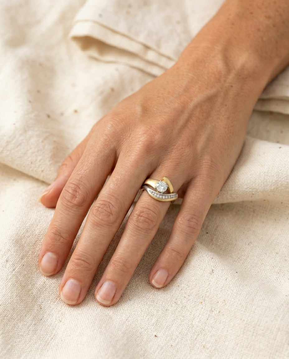 Vintage irregular gold and silver zirconia ring worn on a finger, close hand framing