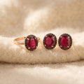 By Sophi Composite Ruby Ring & Earring Set, catalog flat-lay on warm cream wool