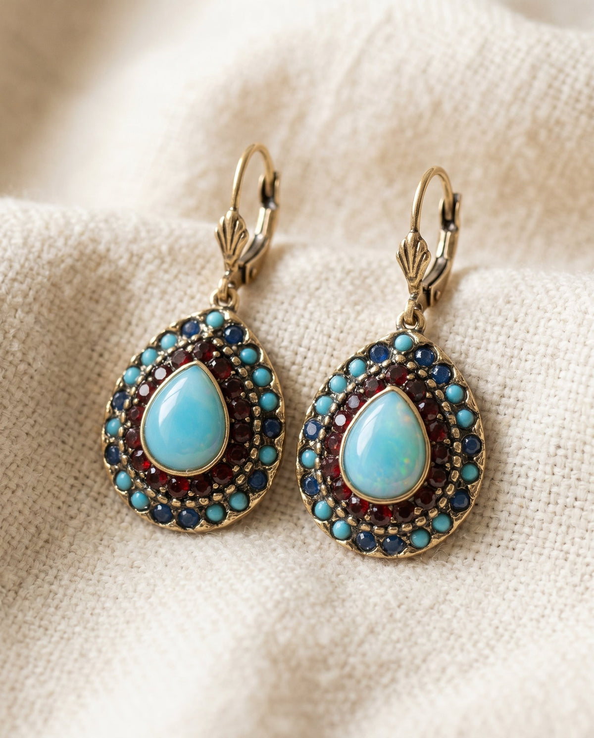 By Sophi Vintage Blue Opal Mandala Drop Earrings flat-lay on warm cream