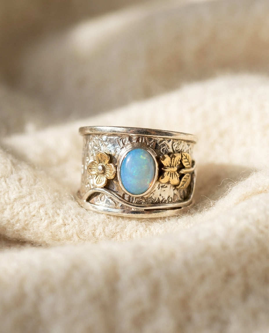 Vintage blue opal ring on cream wool, silver engraved band with small gold florals at the shoulders
