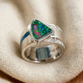 Vintage bright green and blue opal statement ring on cream textile, silver-tone band with diamond accents