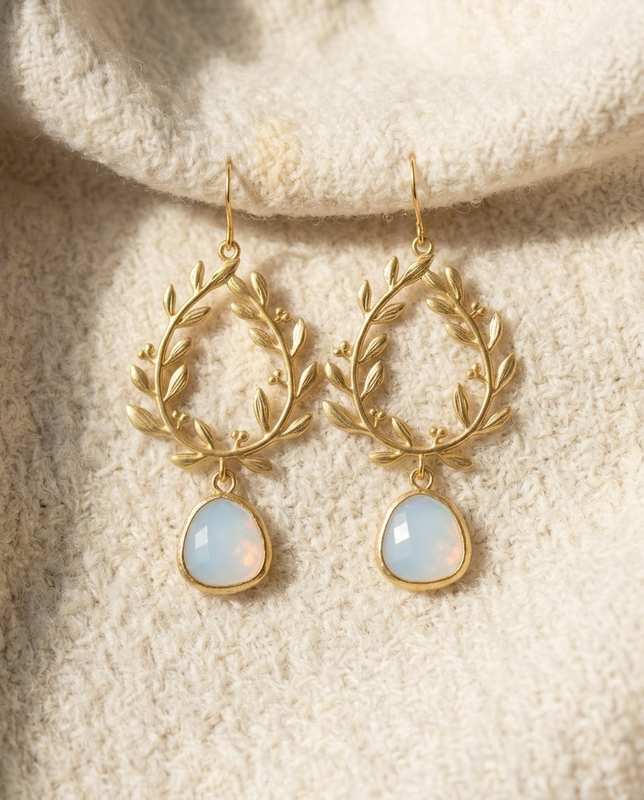 By Sophi Vintage White Opal Golden Drop Earrings flat-lay on warm cream wool