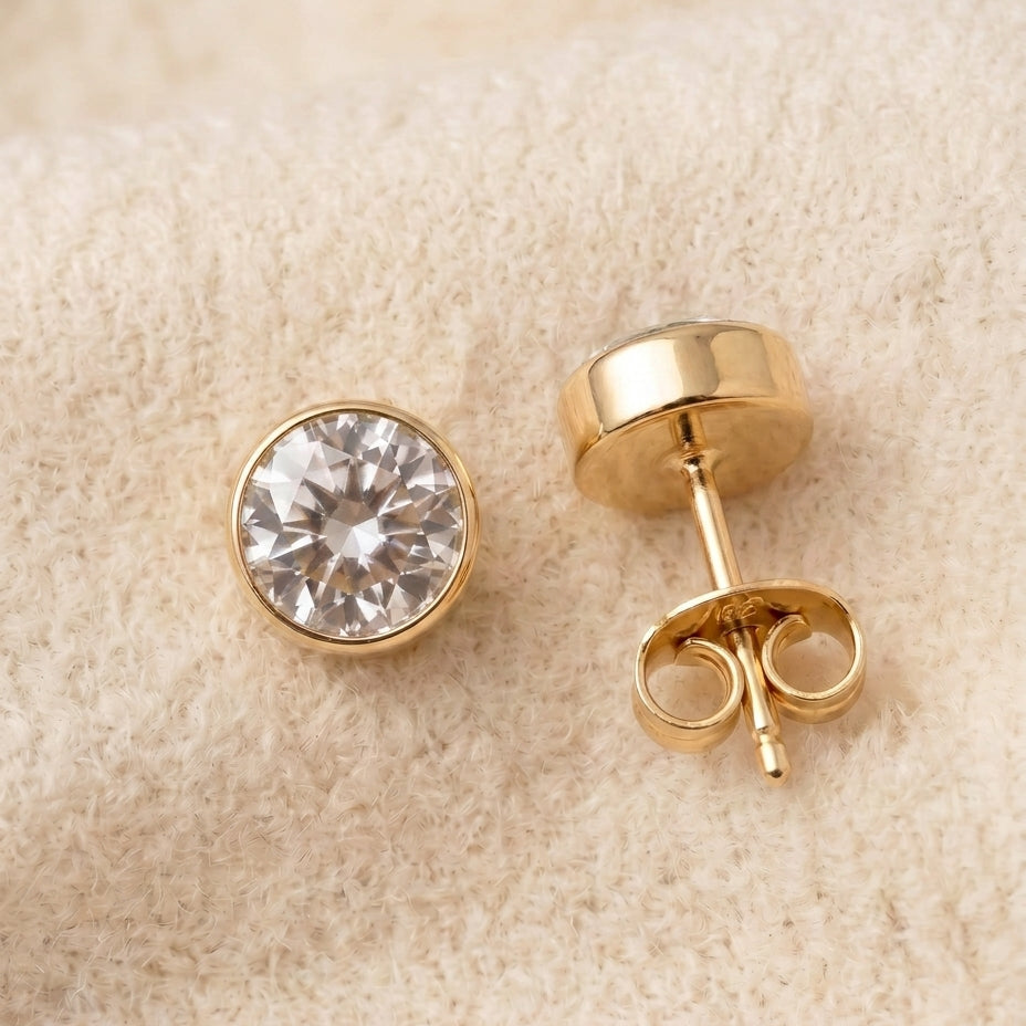 By Sophi White Topaz Birthstone Studs flat-lay on warm cream wool